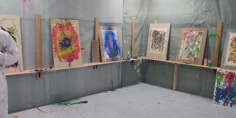 Fertige Bilder trocknen auf den Holzleisten im Atelier