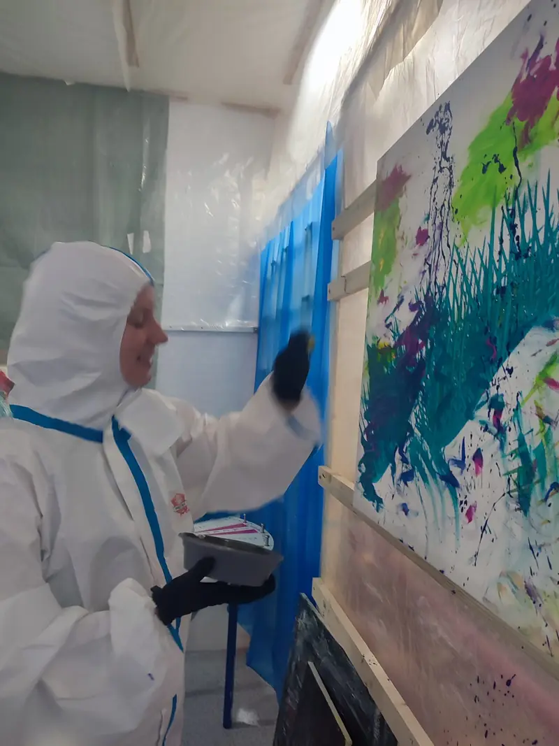 Farbe wird mit Schwung auf die Leinwand geschleudert